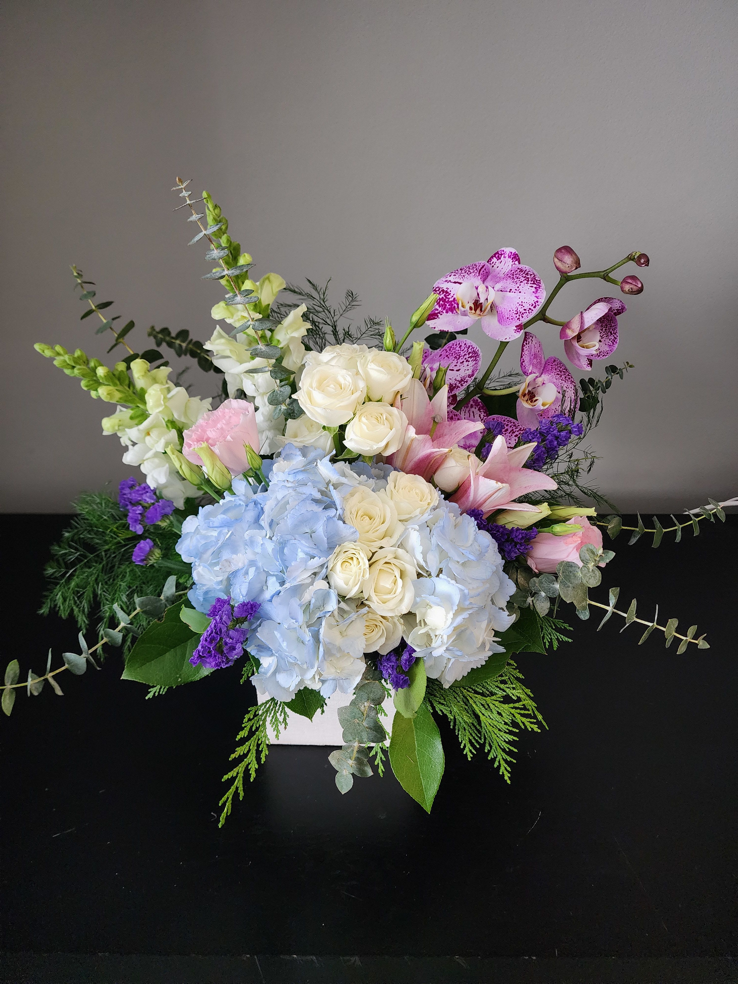 The Hamptons by MG Florist  - A beautiful luxury bouquet designed with a showstopper phalaenopsis orchid, hydrangea, spray roses, lisianthus, statice, and mixed greenery.