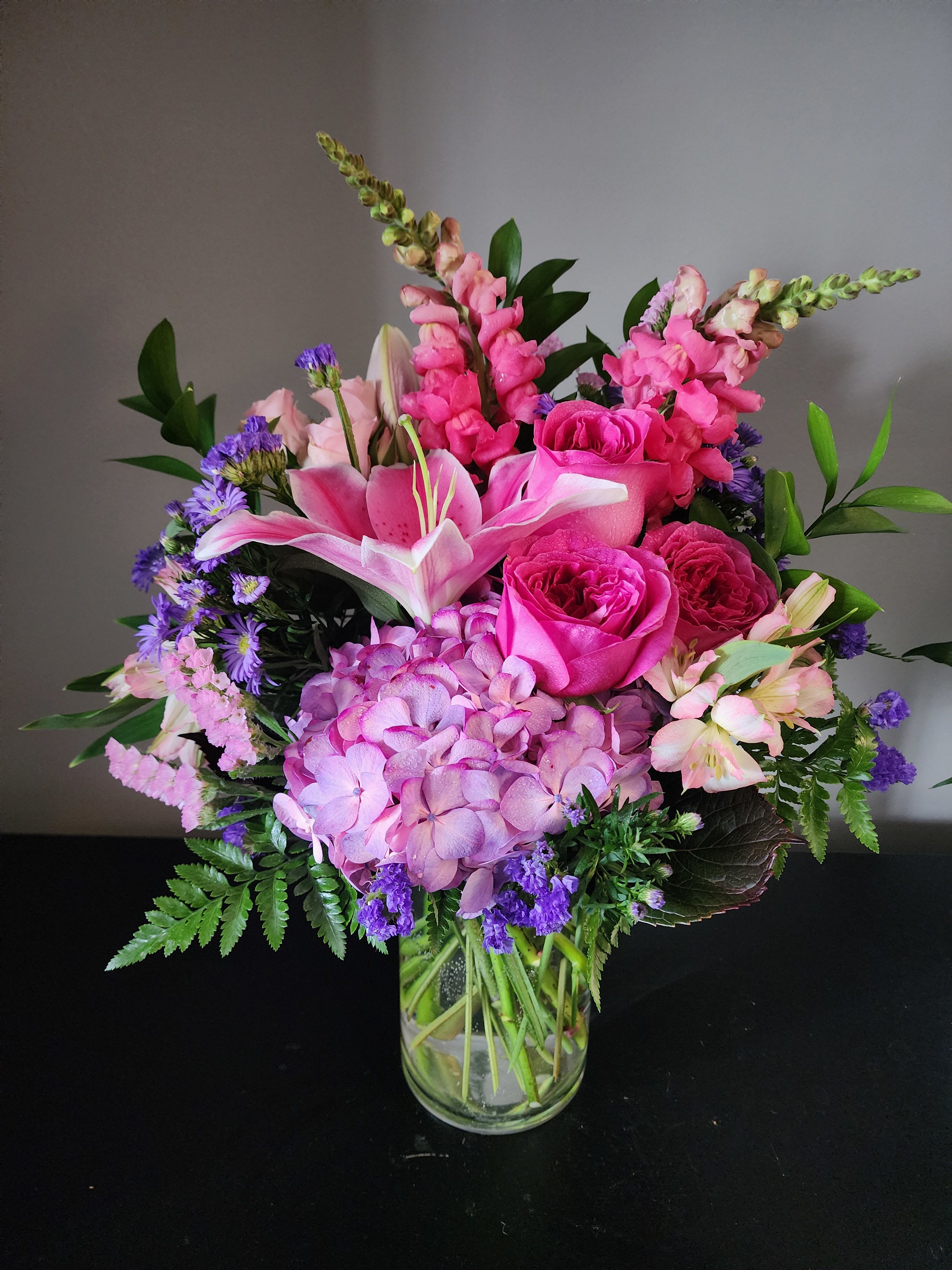 Pink and purple mixed bouquet in a clear glass vase