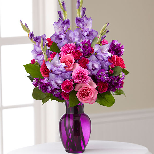 Pink and purple bouquet in a purple glass vase