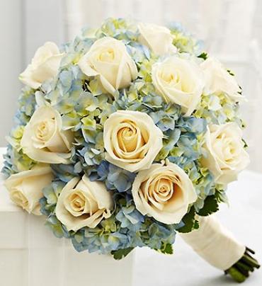 Blue and White Bridesmaid Bouquet - Elegant white roses, blue hydrangea and variegated pittosporum creates an alluring color combination for your bridal party.  Hand-designed bouquet of 12 white roses, blue hydrangea and variegated pittosporum 