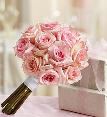 Pink Rose Bouquet - Perhaps the best part about our gorgeous pink rose bouquet is the way each soft, delicate bloom is carefully gathered together to create one unforgettable arrangement for the special day. Accented with crisp white satin ribbon and available in three sizes, the entire bridal party is sure to stand out on their walk down the aisle.  Stunning, hand-designed bouquet of pink roses accented with a crisp white satin ribbon 