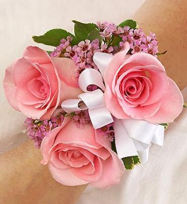 Pink rose wrist corsage with white ribbon and small purple flowers