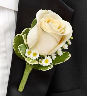 Cream rose boutonniere with small white daisies on a black jacket
