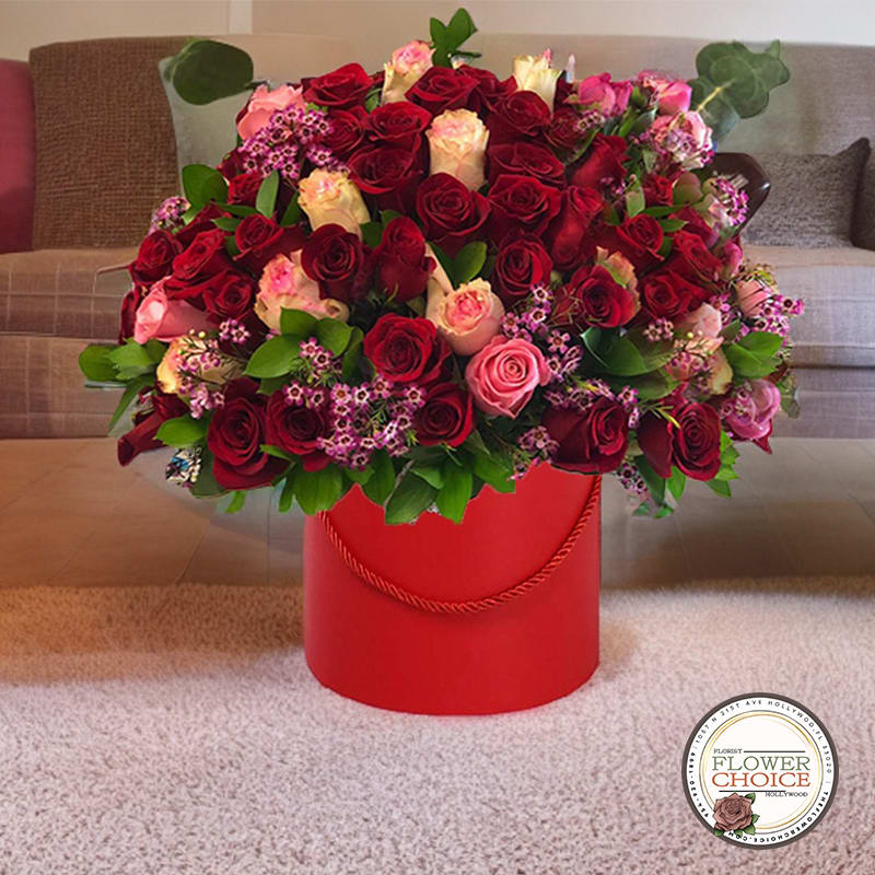 Large bouquet of red and pink roses in a red hat box