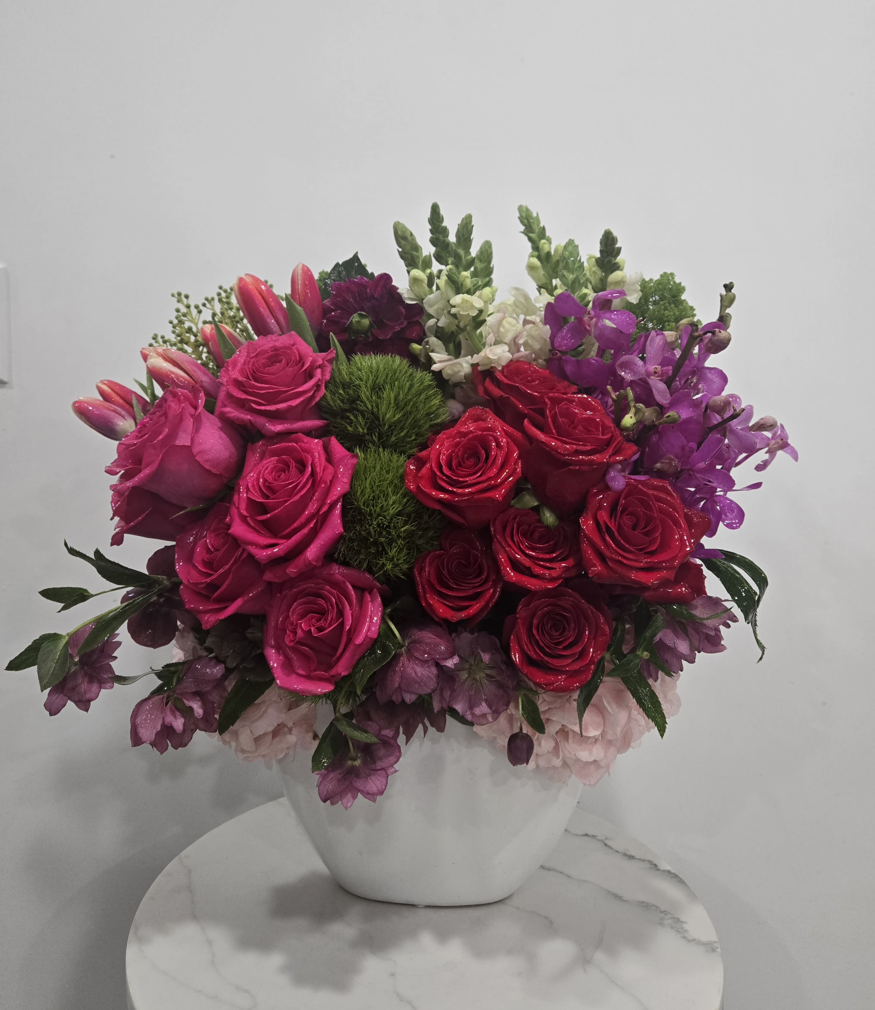 Pink and red rose arrangement in a white vase