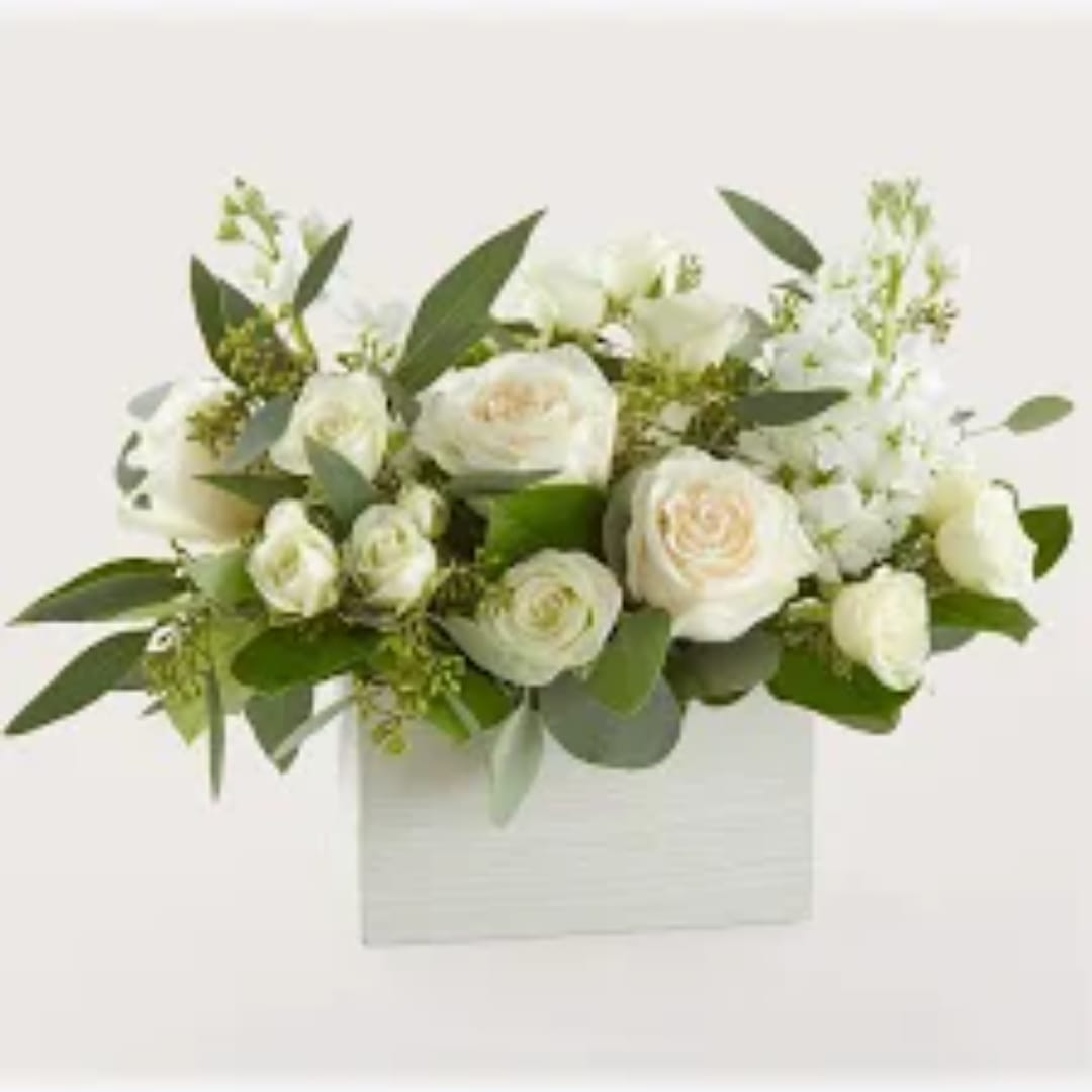 White rose bouquet in a white box with green foliage
