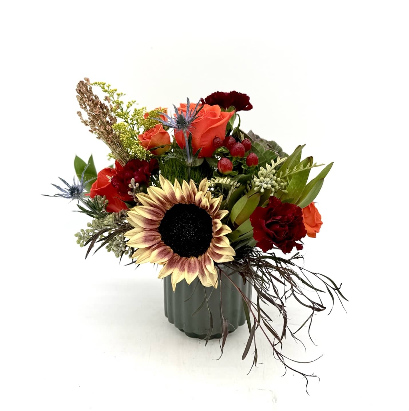 Sunflower and orange rose arrangement in a green vase
