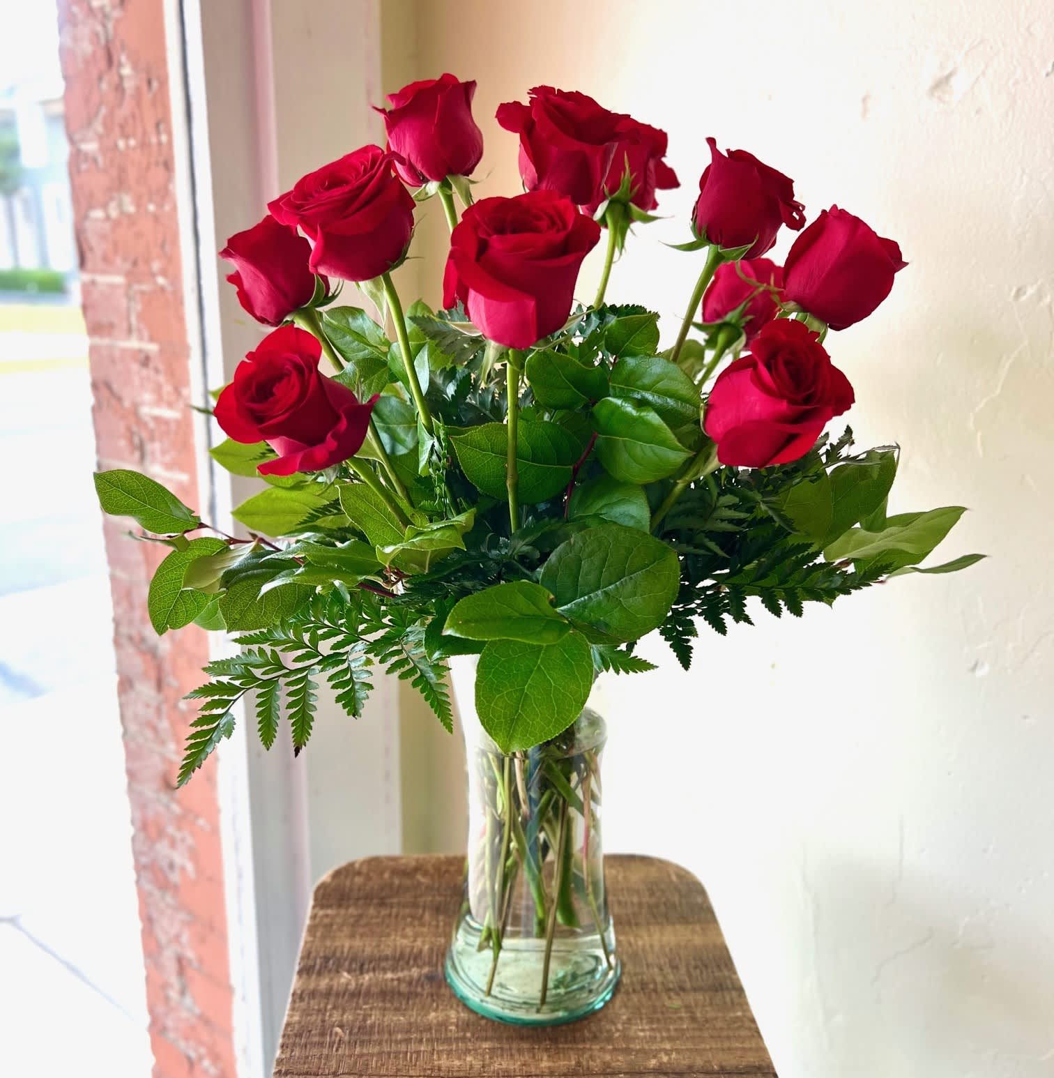 Red roses arranged in a clear glass vase