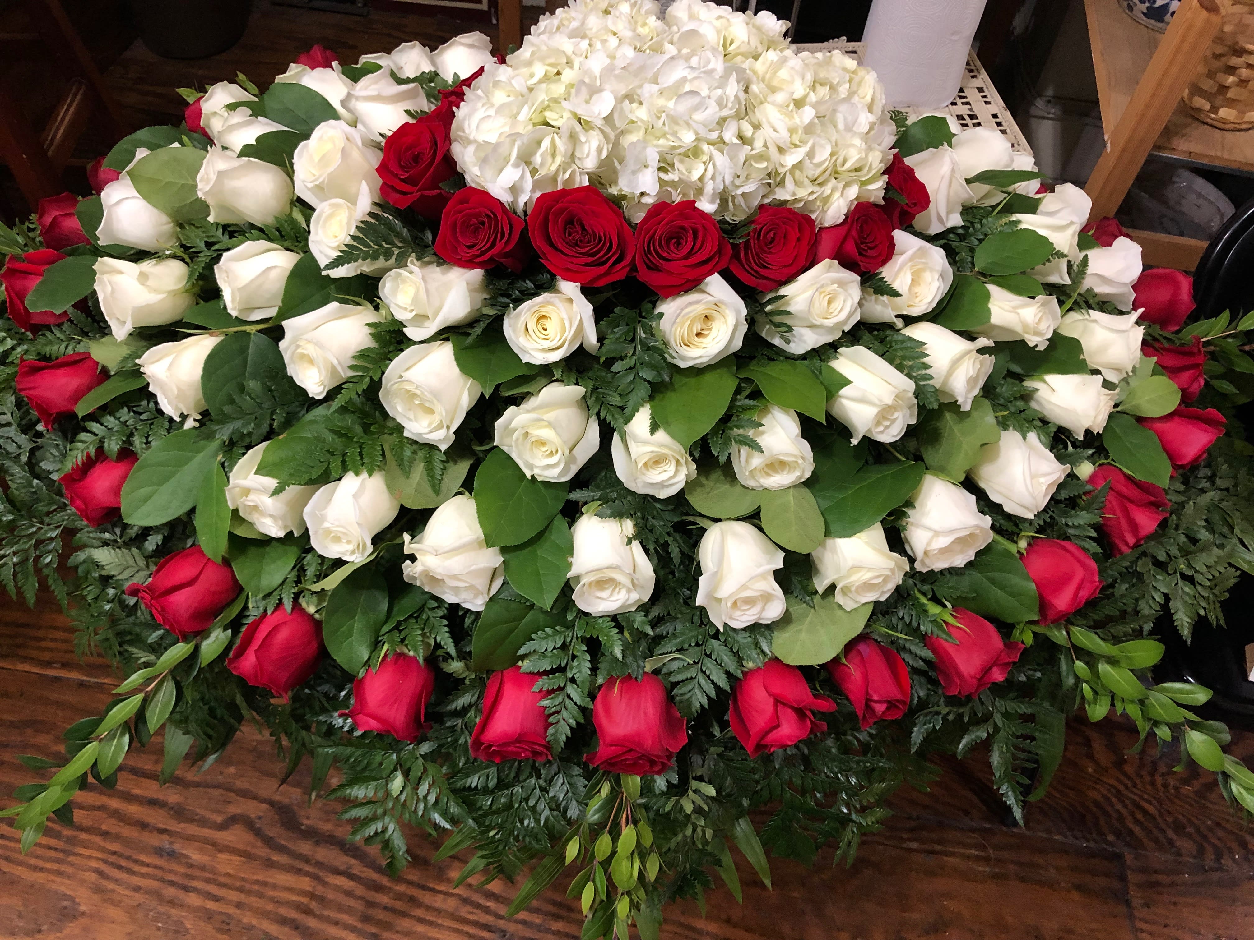 Large arrangement of red and white roses with white hydrangeas