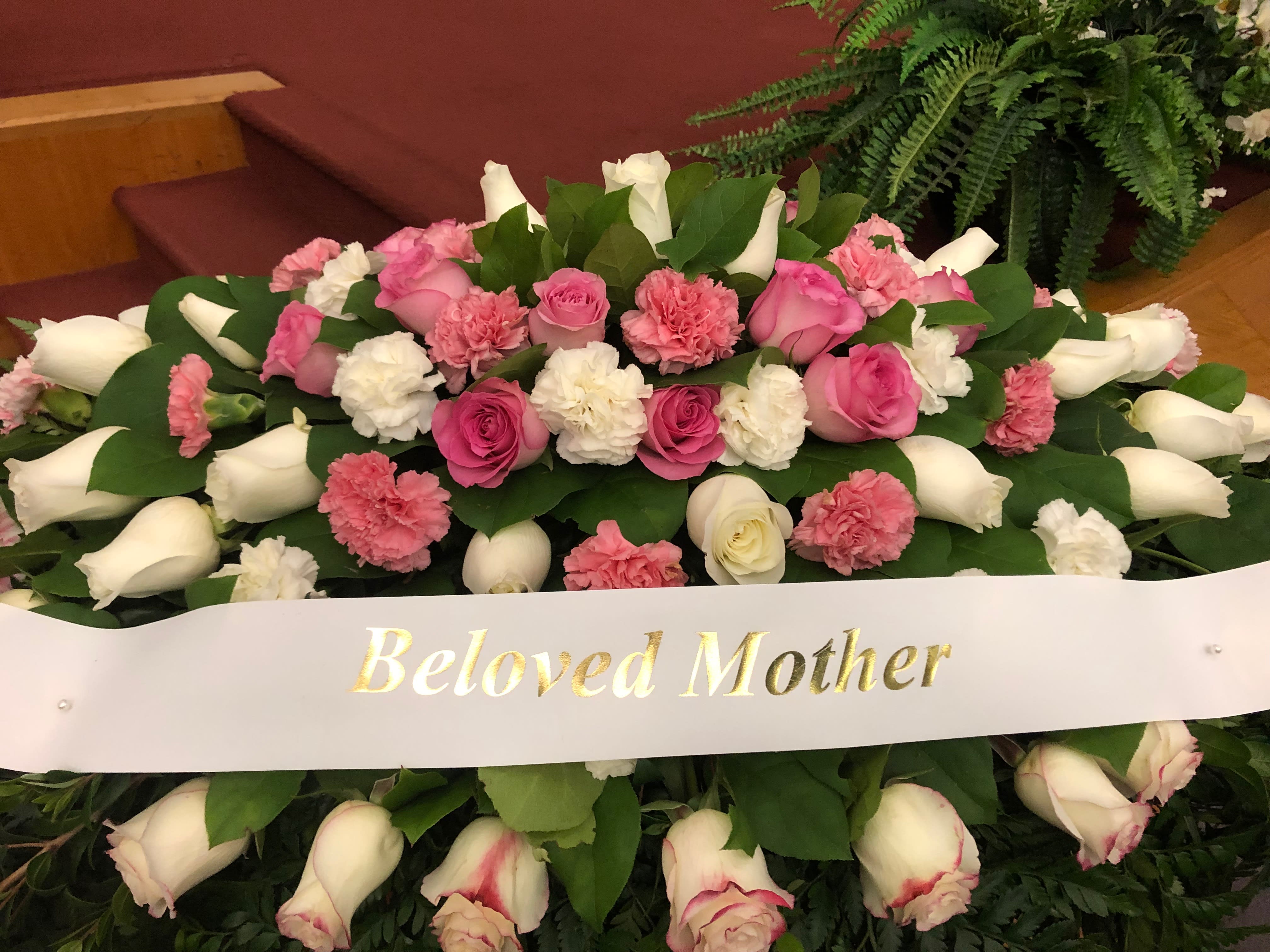 Pink and white floral spray with a "Beloved Mother" ribbon
