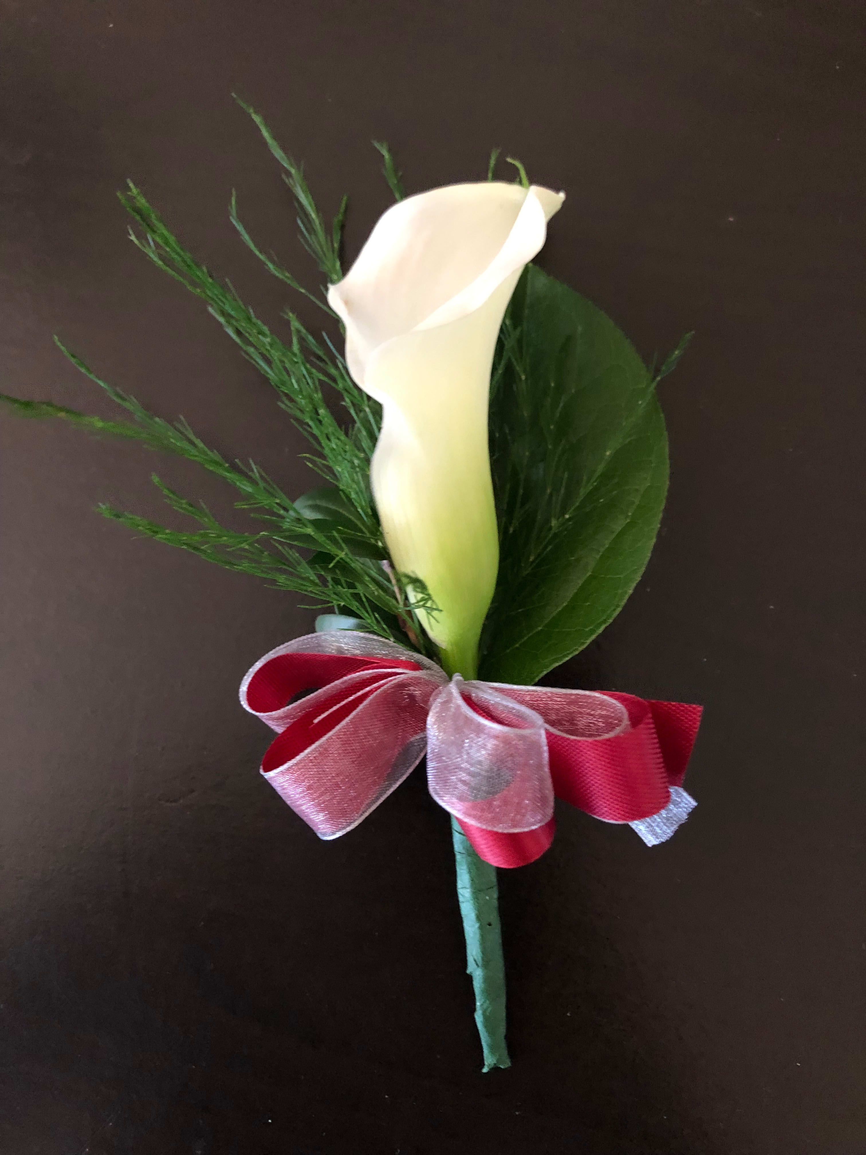 White calla lily boutonniere with red ribbon bow