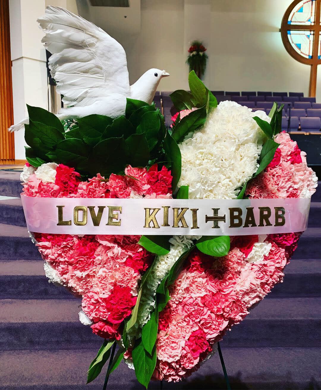 Heart-shaped pink and white carnation tribute with a white dove