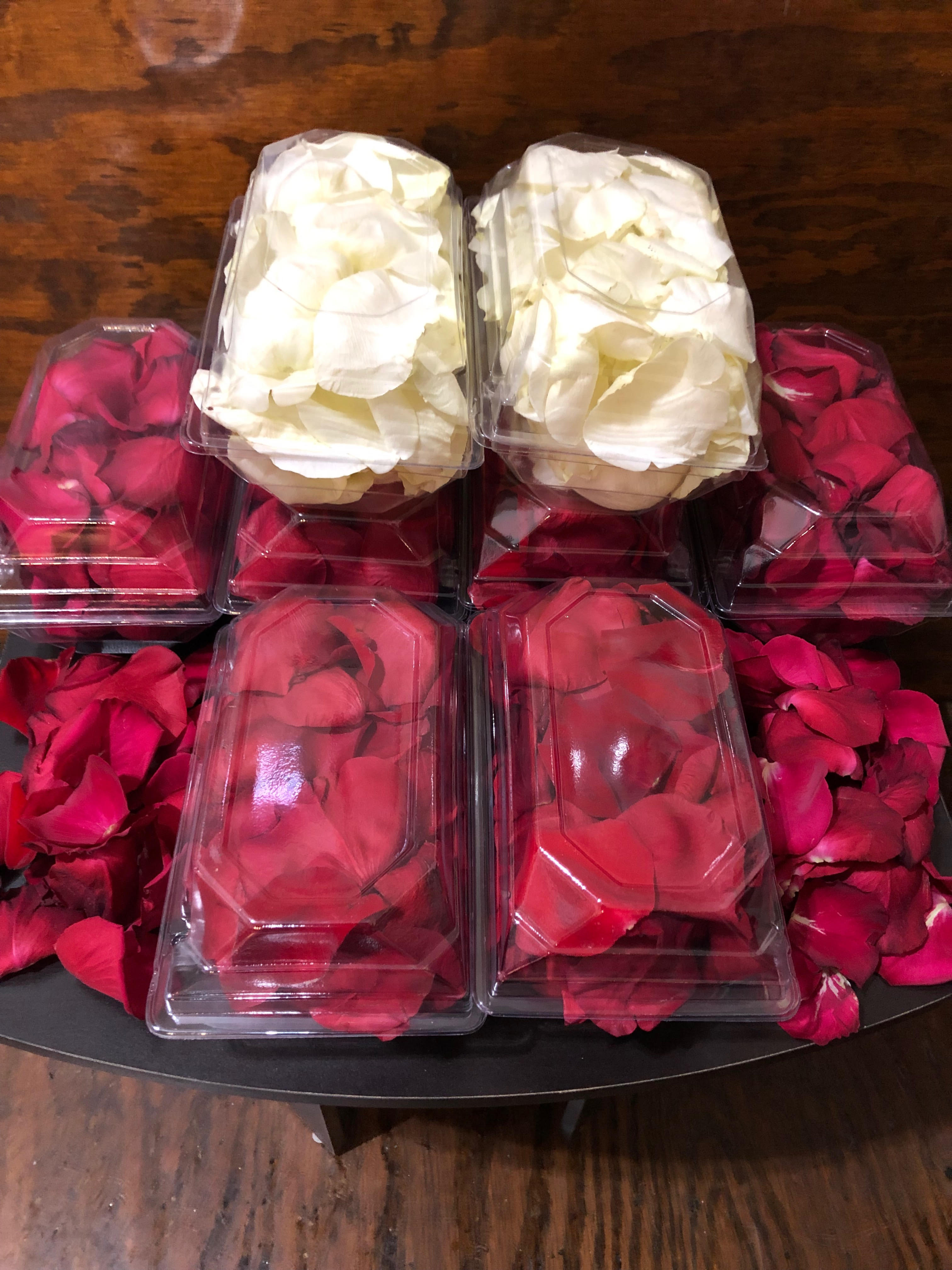Plastic boxes filled with red and white rose petals
