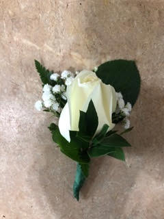 White rose boutonniere with baby's breath and green leaves