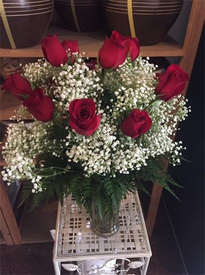 Bouquet of red roses and white baby's breath in a glass vase