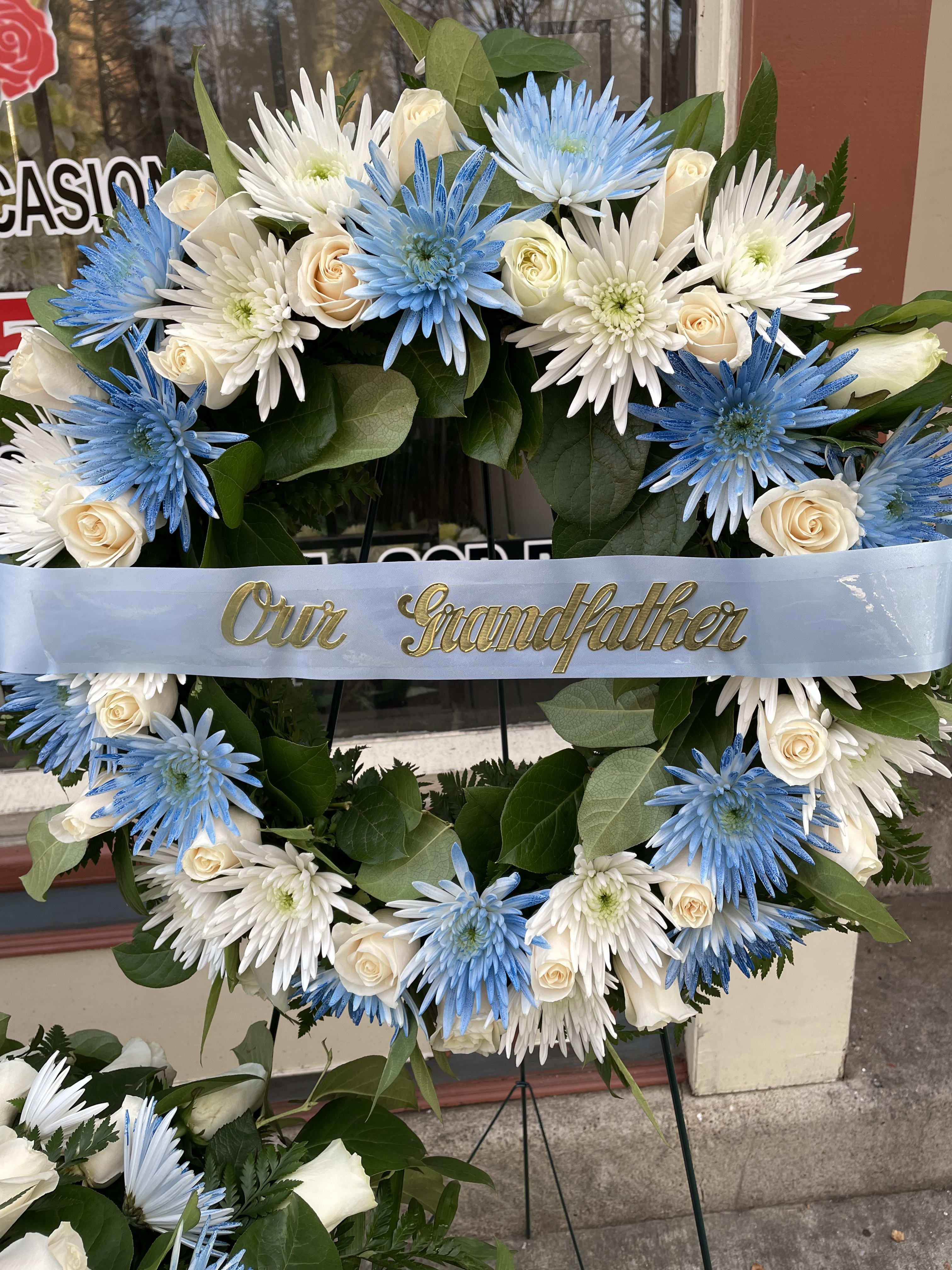 Blue and white floral wreath with a ribbon reading "Our Grandfather"