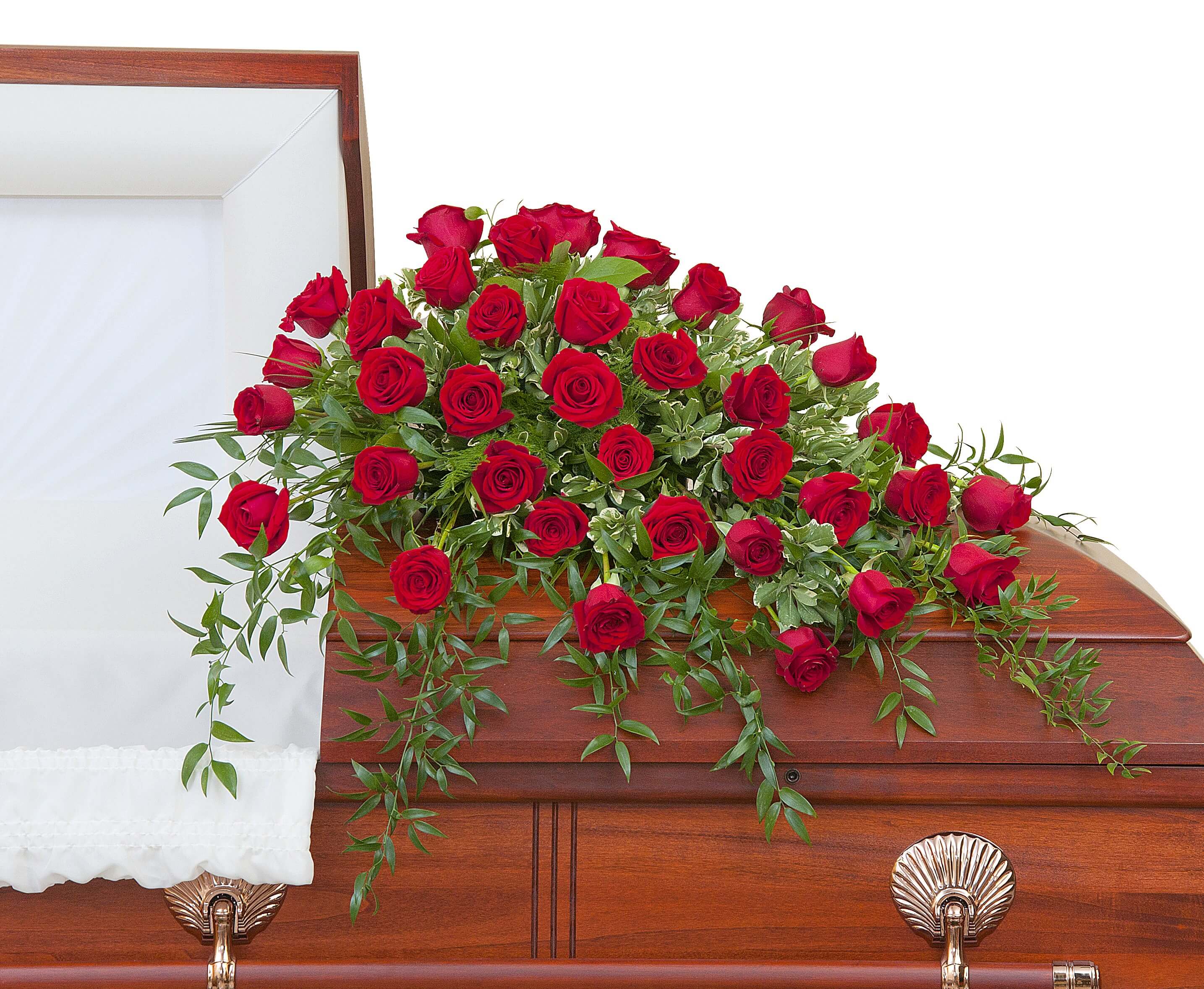 Red rose casket spray arranged across a polished wooden casket.