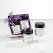 Gift set of small white jars with black lids in a purple ribboned box