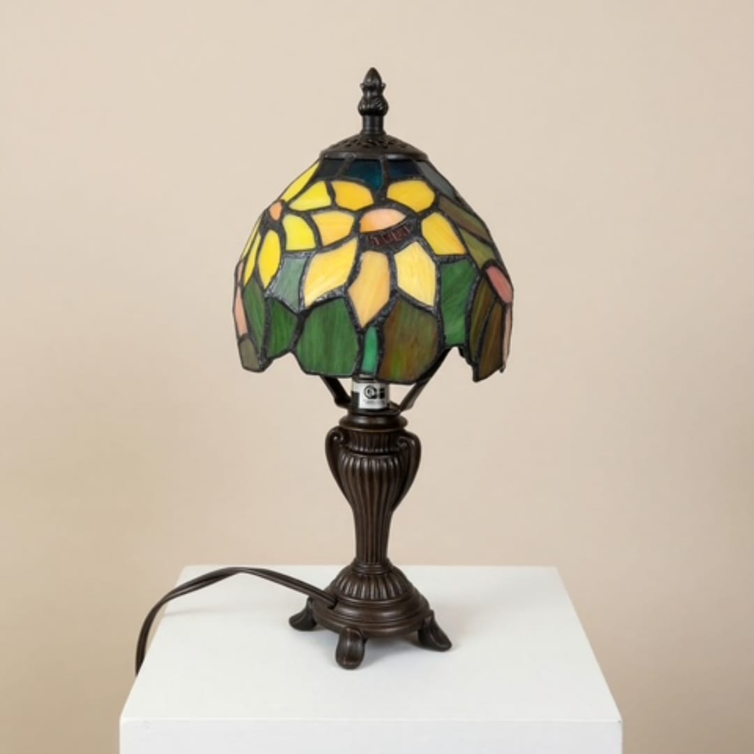 Stained glass table lamp with a floral shade on a white pedestal