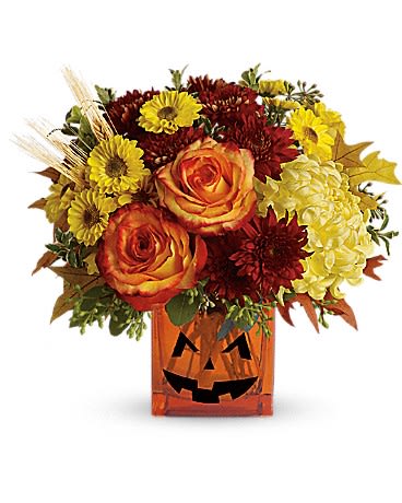 Autumn bouquet in a jack-o'-lantern vase with orange roses and yellow flowers
