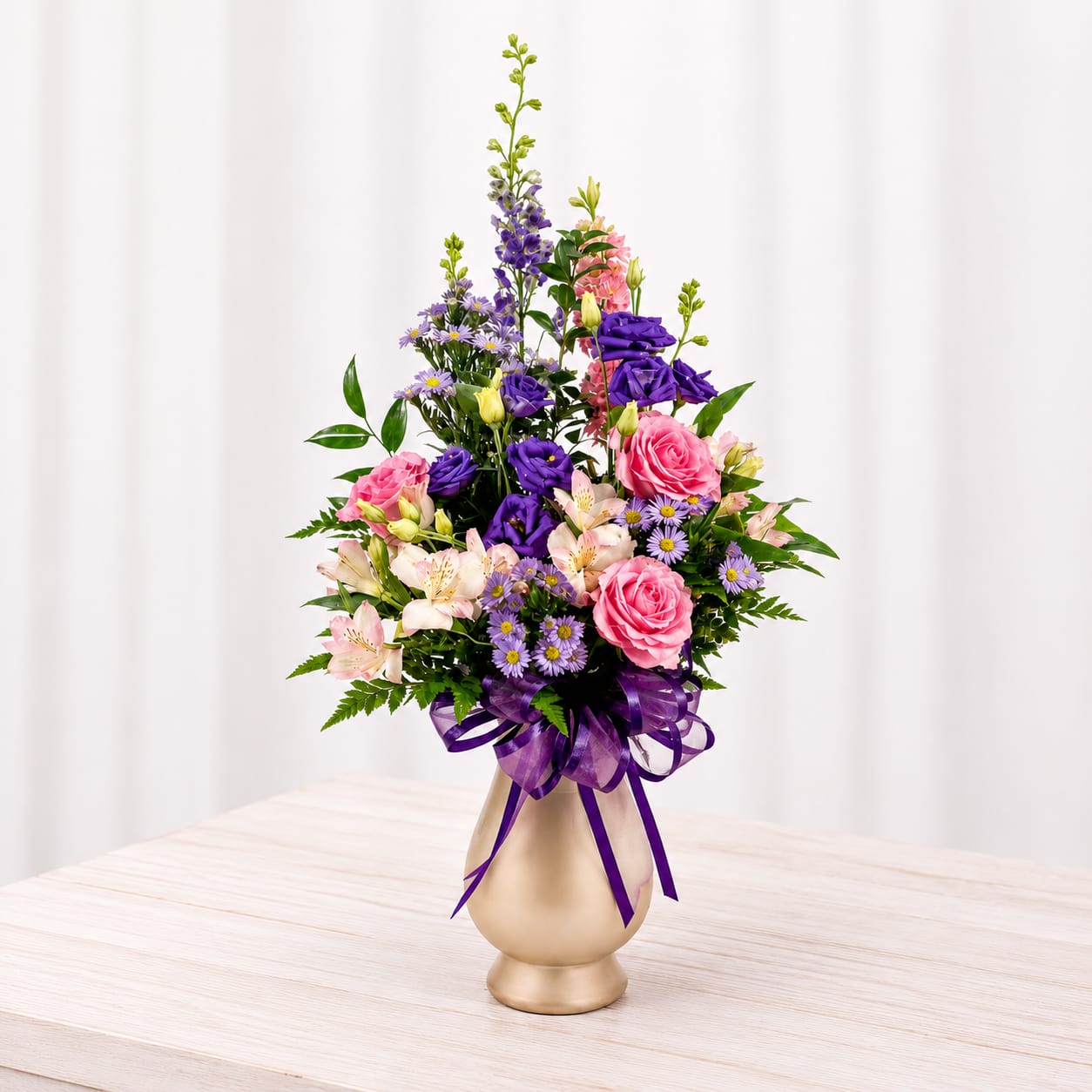 Elizabeth Ann - The Elizabeth Ann is sure to make a statement. It's tall and grand with a mix of purples and pinks. Vase color may vary