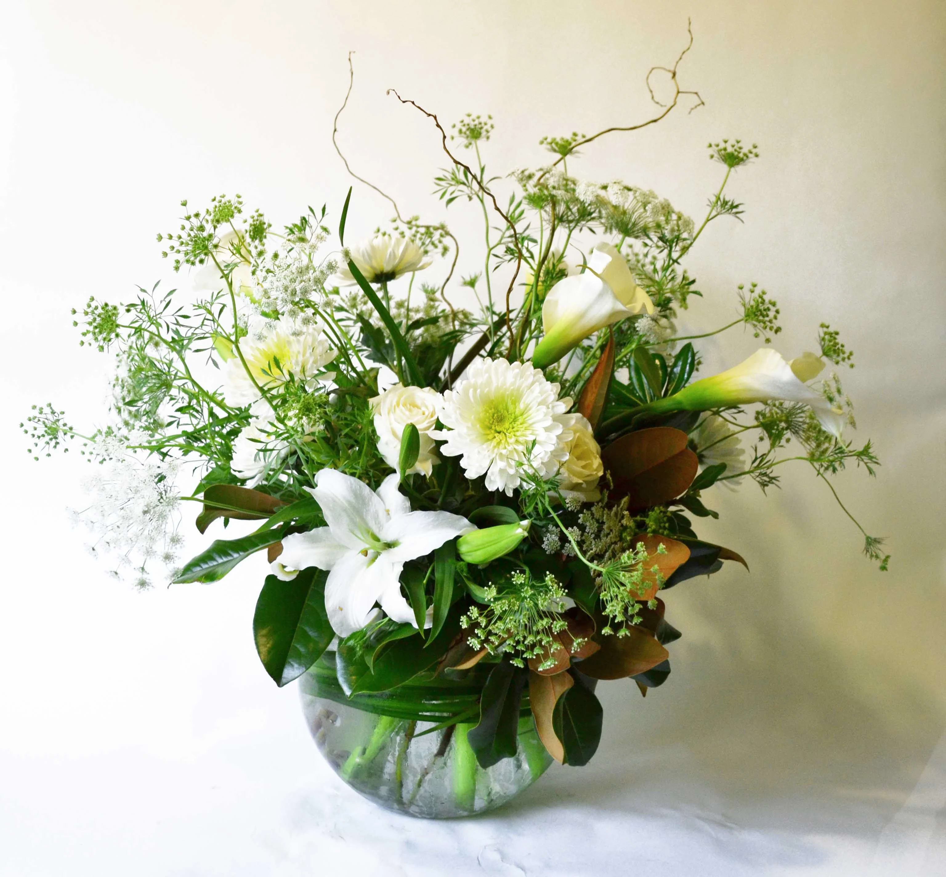 Wishes of Comfort and Peace - A glass bowl filled with Roses, Cremon, Calla Lilies, Curly Willow, Disbuds, Queen Ann's Lace, Magnolia Leaf, Seasonal Greens