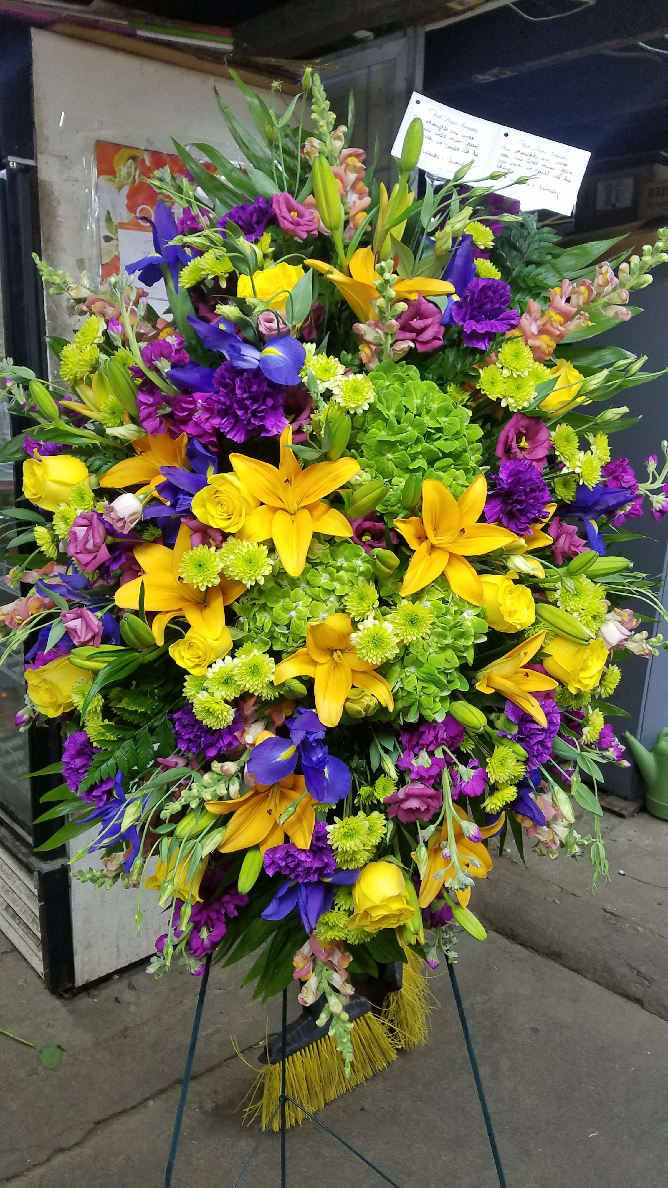 Large standing spray with yellow lilies, purple flowers, and green hydrangeas