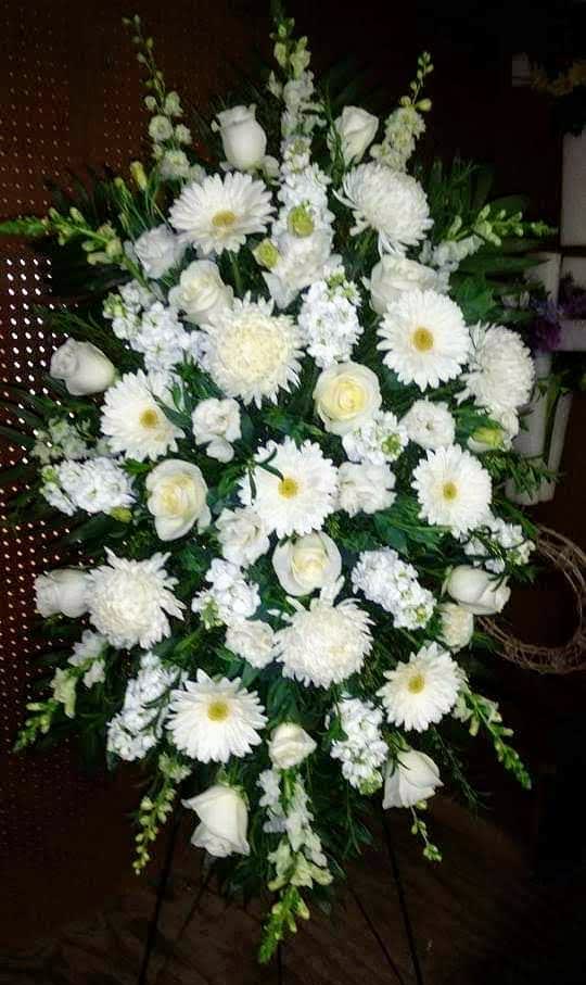 White funeral spray with daisies, roses, and chrysanthemums