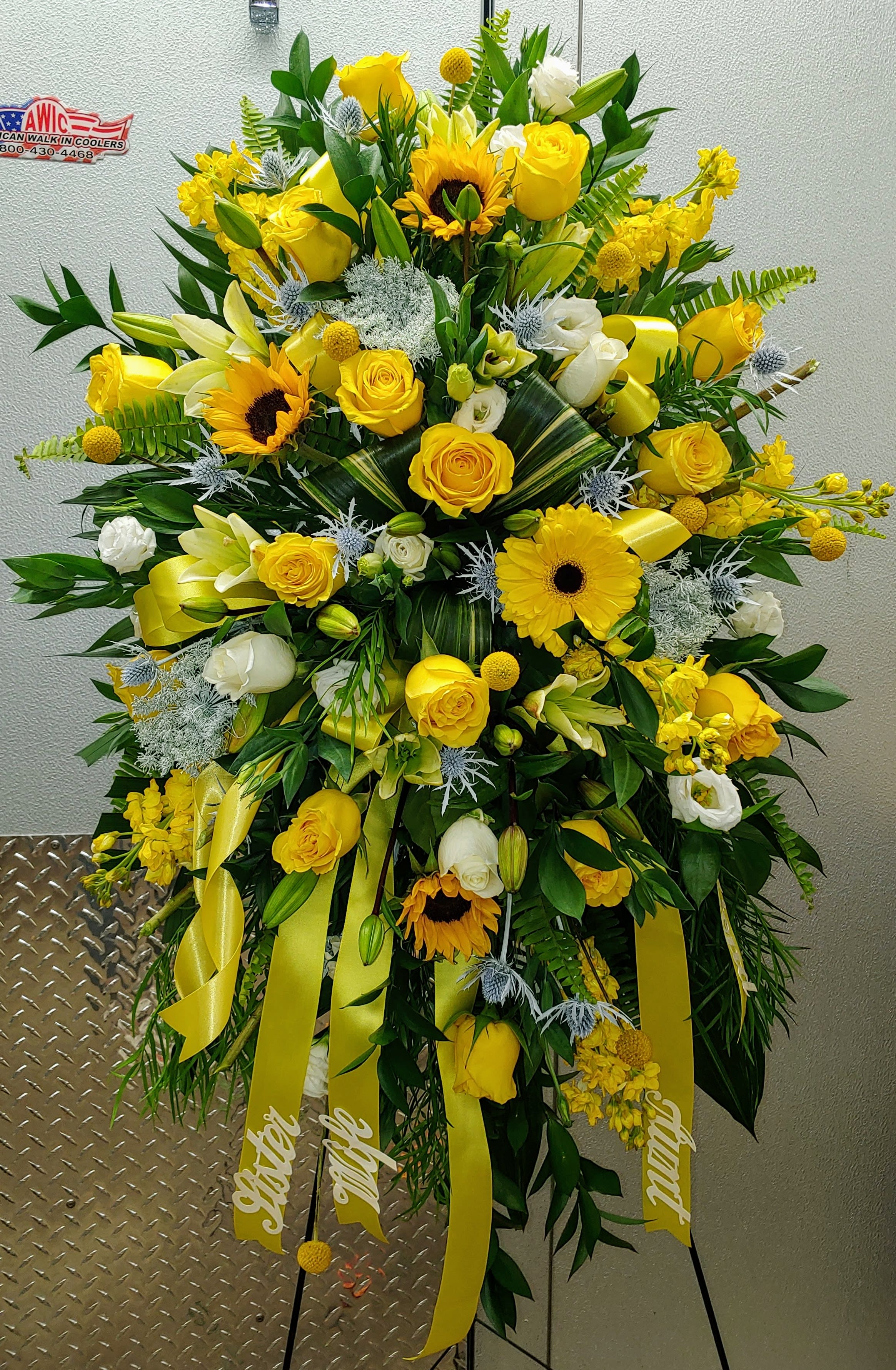 Large yellow and white floral standing spray with ribbons