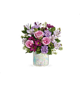 Pink and lavender flower arrangement in a iridescent vase