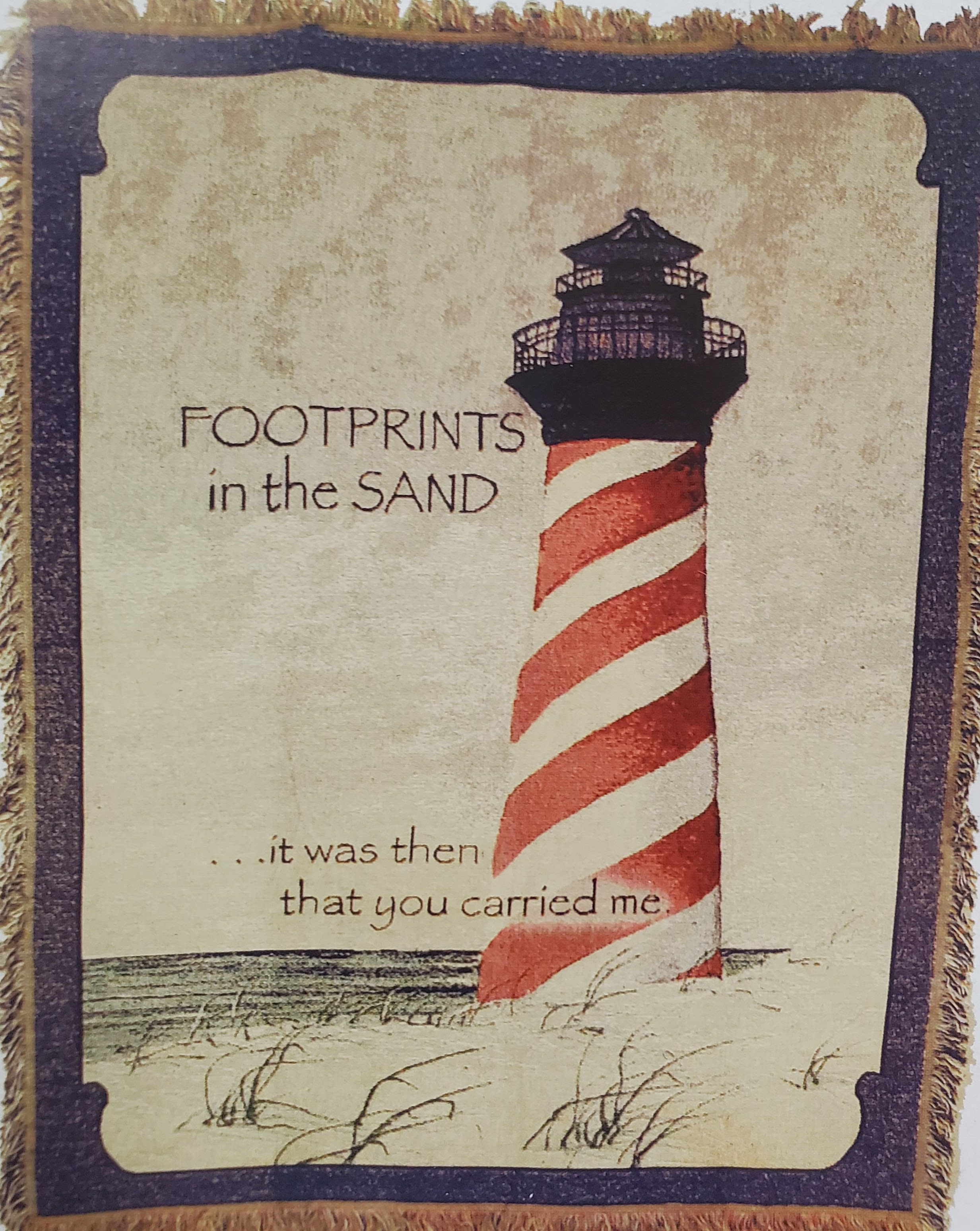 Decorative wall hanging with a lighthouse and the words "Footprints in the Sand"