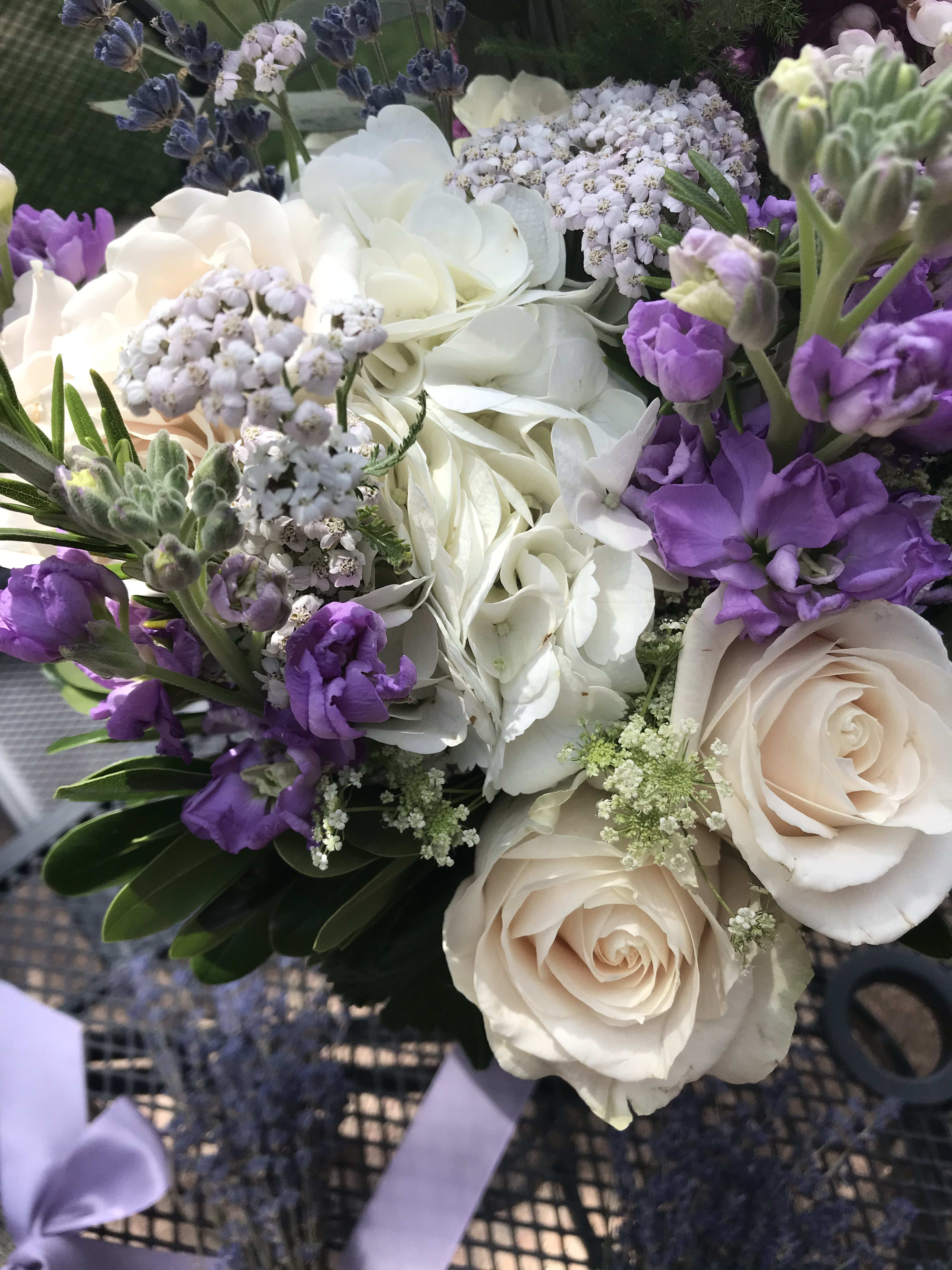 Bouquet of white roses, hydrangea, and purple flowers