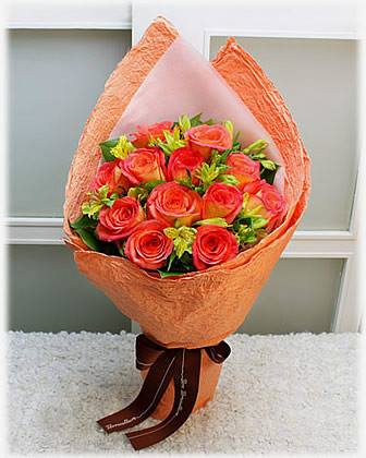 Bouquet of orange and red roses wrapped in peach paper