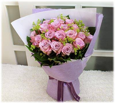 Bouquet of pink roses wrapped in lavender paper