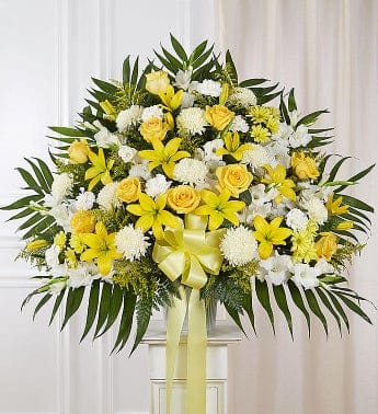 Yellow and white floral standing spray with a ribbon bow