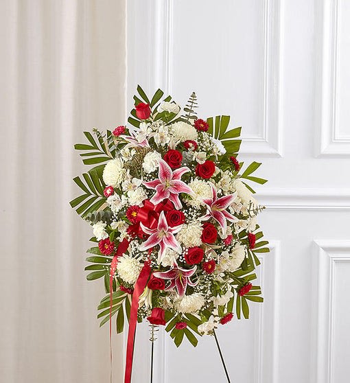 Standing floral spray with red and white flowers on an easel