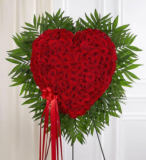 Heart-shaped red rose standing spray with a red ribbon