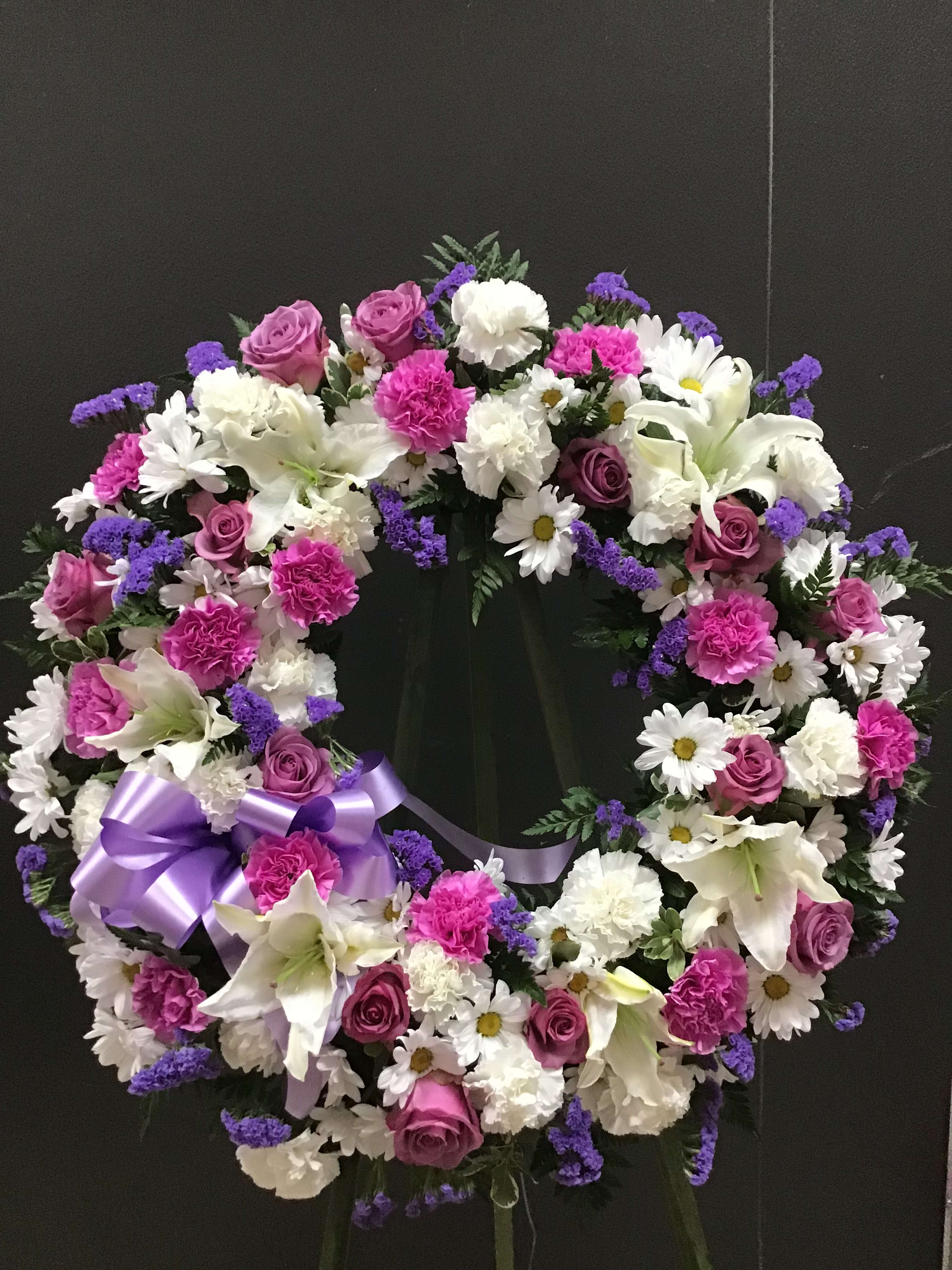 Heart-shaped floral wreath with pink, white, and purple flowers