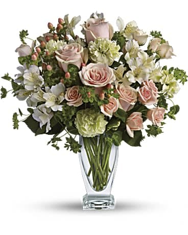 Pink roses and white flowers arranged in a clear glass vase