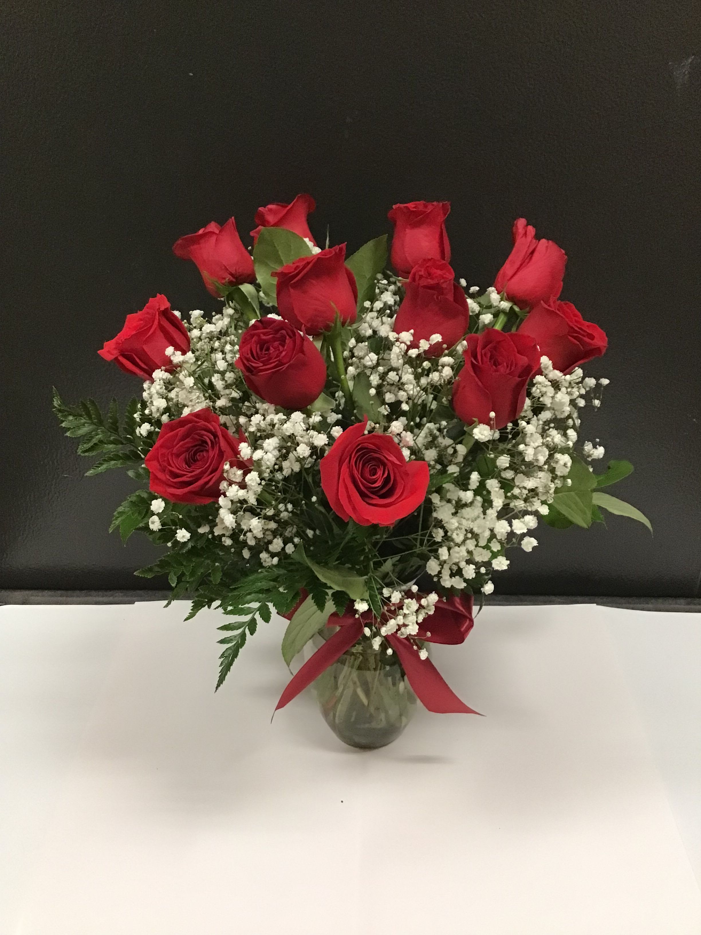 Bouquet of red roses and baby's breath in a glass vase
