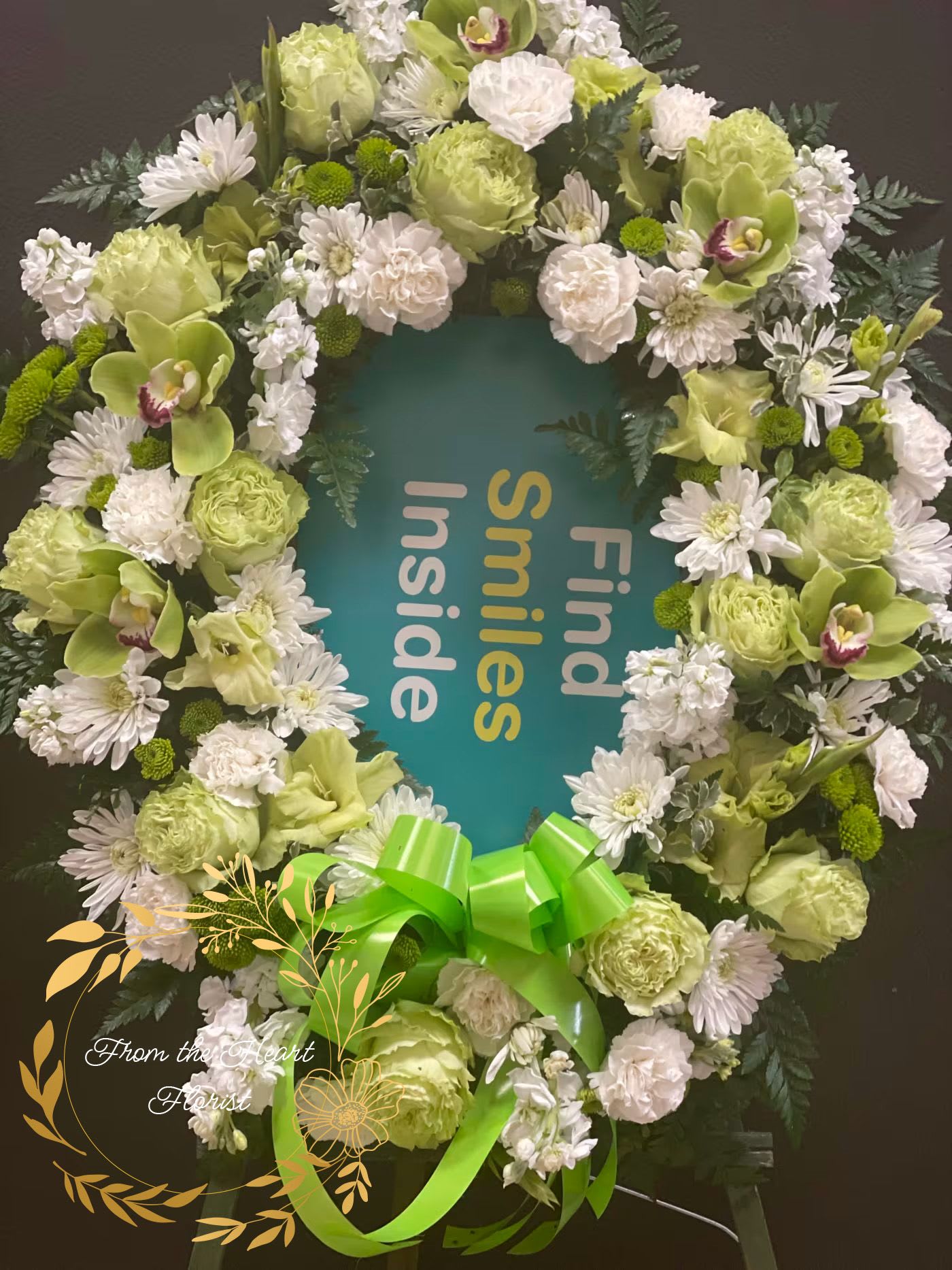 Green and white floral wreath with a bright ribbon bow