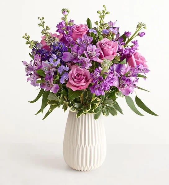 Romantic Lavender - A perfect gift for mom. This garden-inspired gathering features soothing lavender and purple, along with accents of cascading greenery. It’s arranged in our keepsake White Modern Vase, with a tapered design and matte finish that complements the beauty of every bloom.