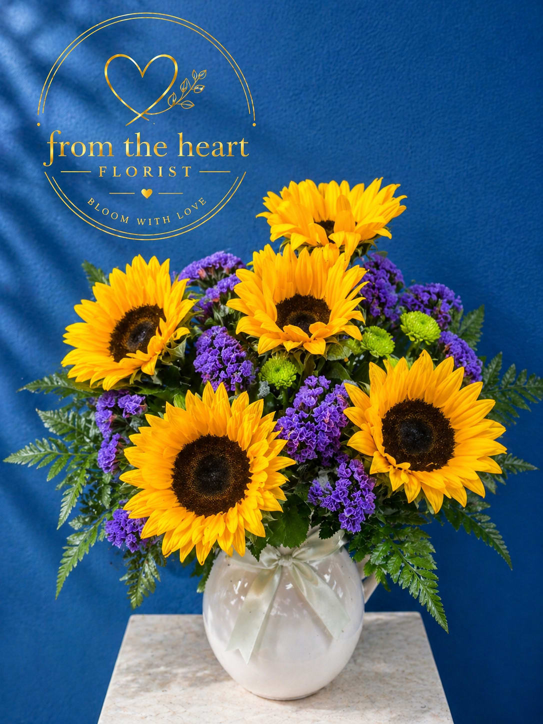 Pitcher Of Sunshine  - Shine some light for mom this Mother' Day. This beautiful pitcher arrange full of sunflower statice, and green button 