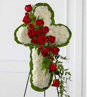 The FTD® Floral Cross Easel - The FTD® Floral Cross Easel is a symbol of love and faith to honor the deceased at the final farewell service. White carnations are arranged to form a cross in which an accent of red roses, spray roses, and lush greens are draped across the center, creating a beautiful display of serene elegance. Displayed on a wire easel. Approximately 38"H x 24"W. Your purchase includes a complimentary personalized gift message.