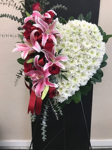 Heart-shaped floral spray with pink lilies, red roses, and white chrysanthemums