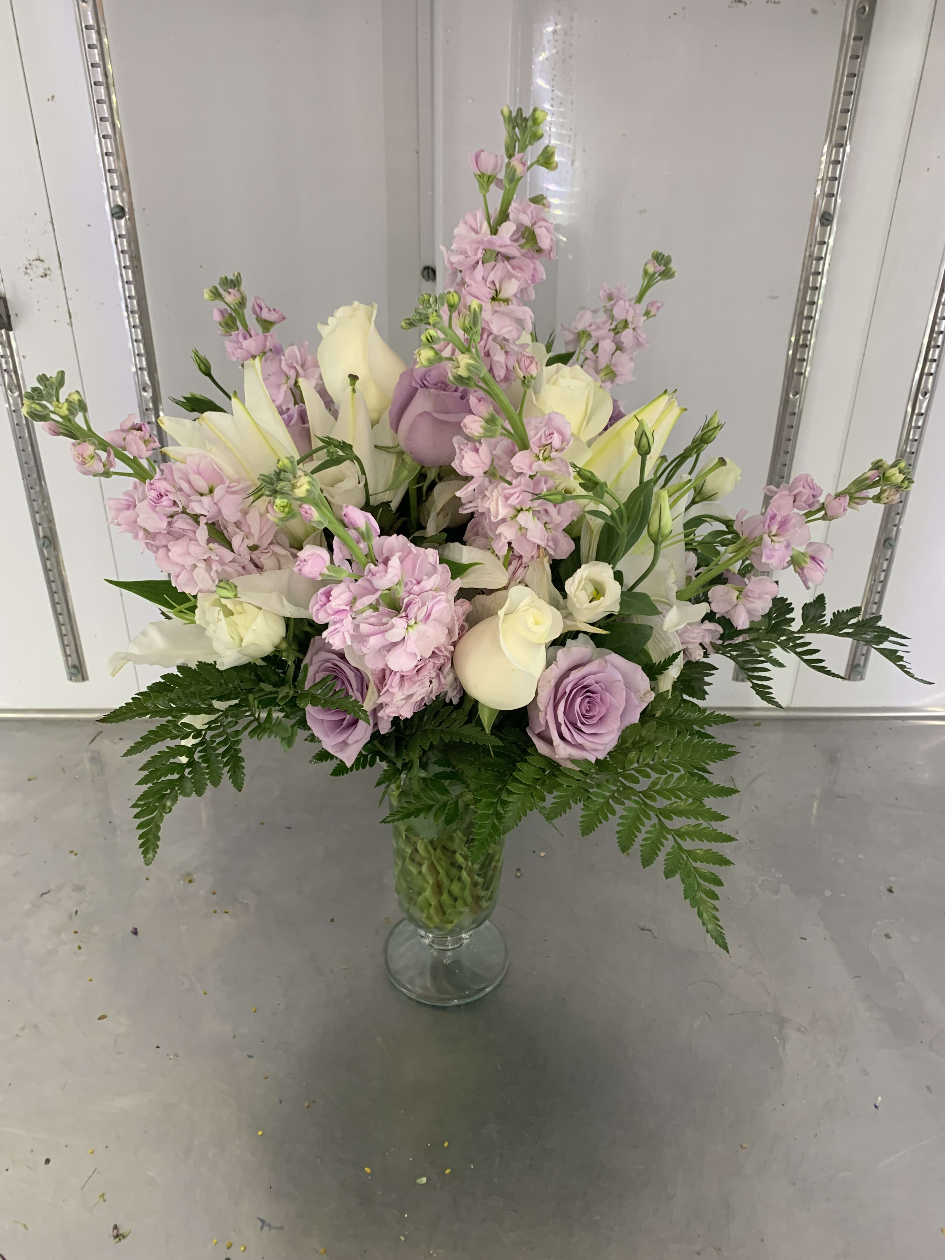 Pastel bouquet of roses, lilies, and pink stock in a glass vase