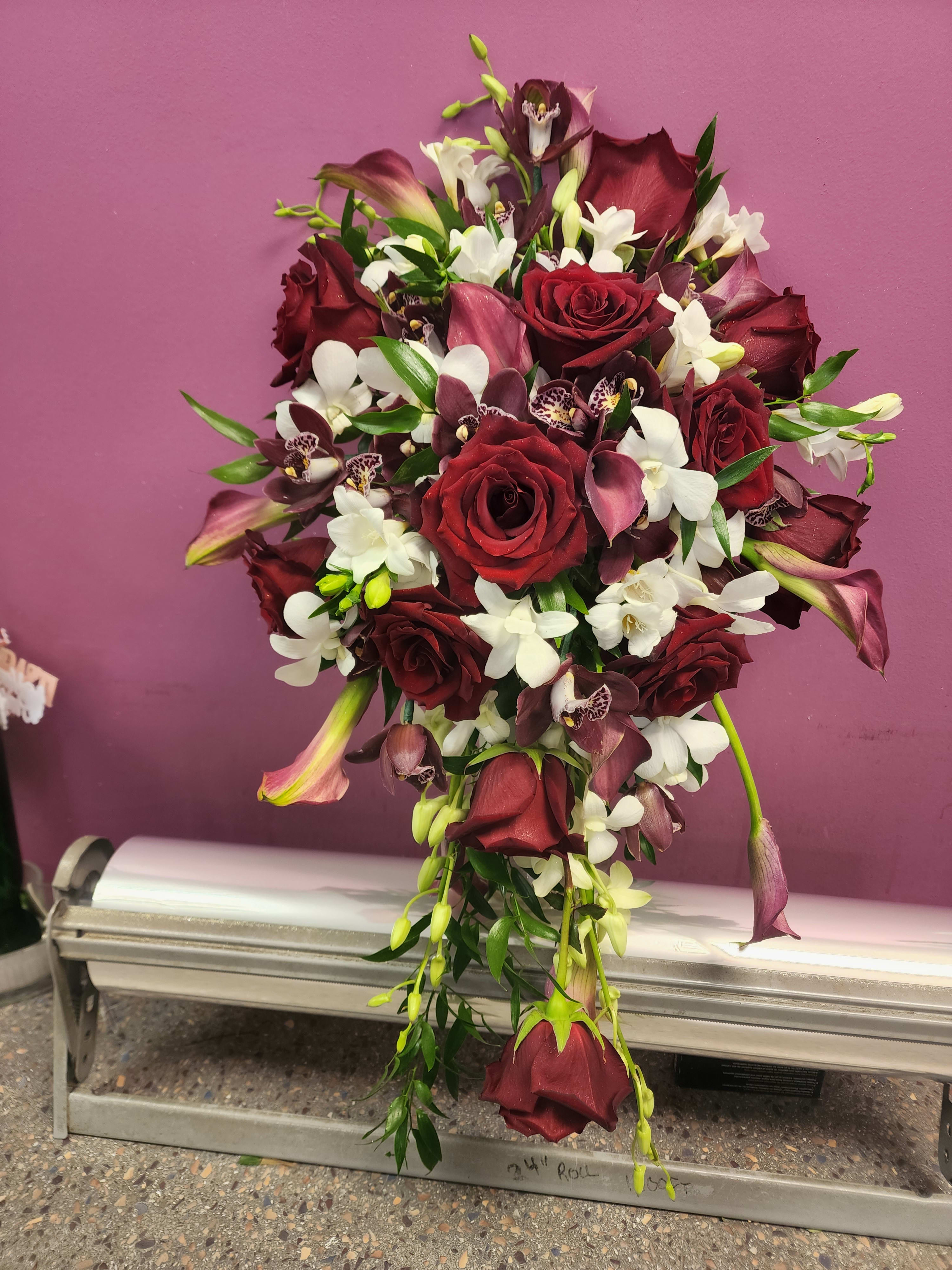 Cascade bouquet of red roses, white orchids, and burgundy calla lilies