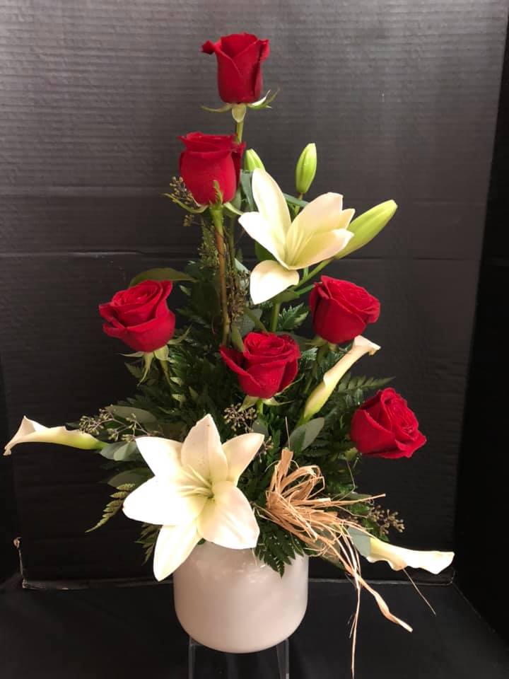 Red roses and white lilies arranged in a white vase