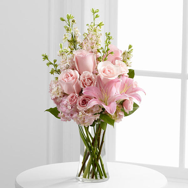 The FTD Wishes &amp; Blessings Bouquet - The FTD® Wishes &amp; Blessings™ Bouquet is a stunning way to offer your condolences for their loss and commemorate the life of the deceased. Soft pink roses spray roses Oriental lilies hydrangea and larkspur are brought together in a clear glass vase to create an eye-catching display of soft serenity.