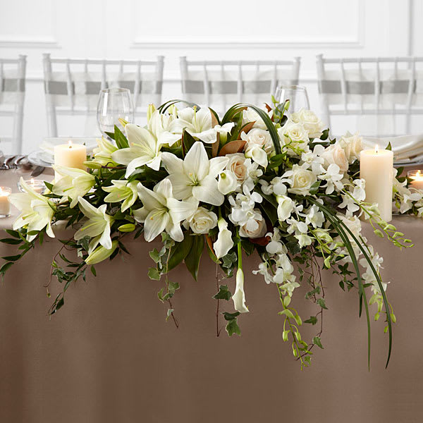 White floral centerpiece with candles on a table